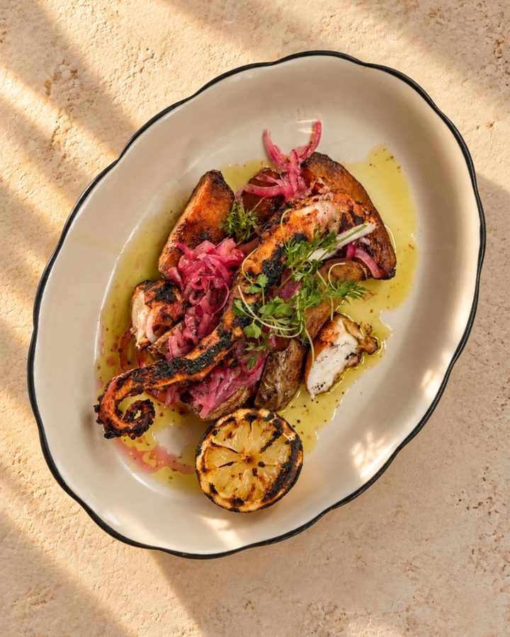 Grilled octopus with pickled onion and a charred lemon half